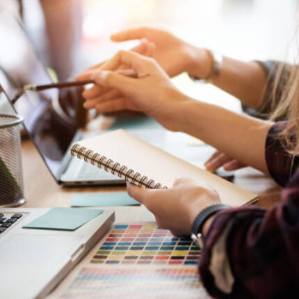 Photo of two people pointing at laptop monitor