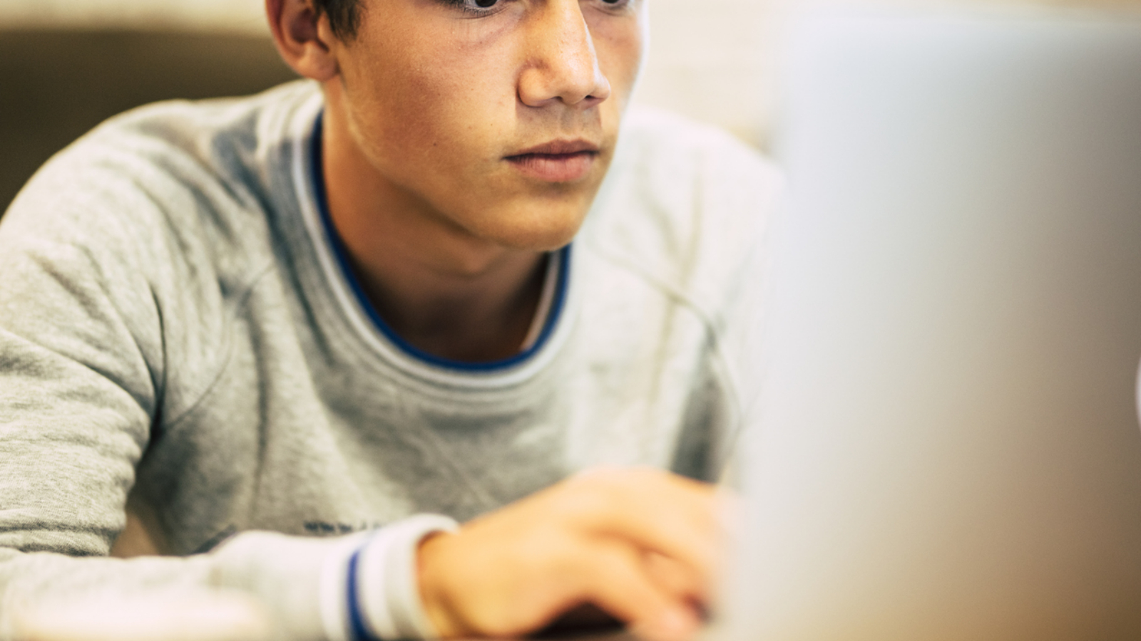 Portrait of teenager at home using his laptop for watching videos or playing games - one man working at the office with his computer