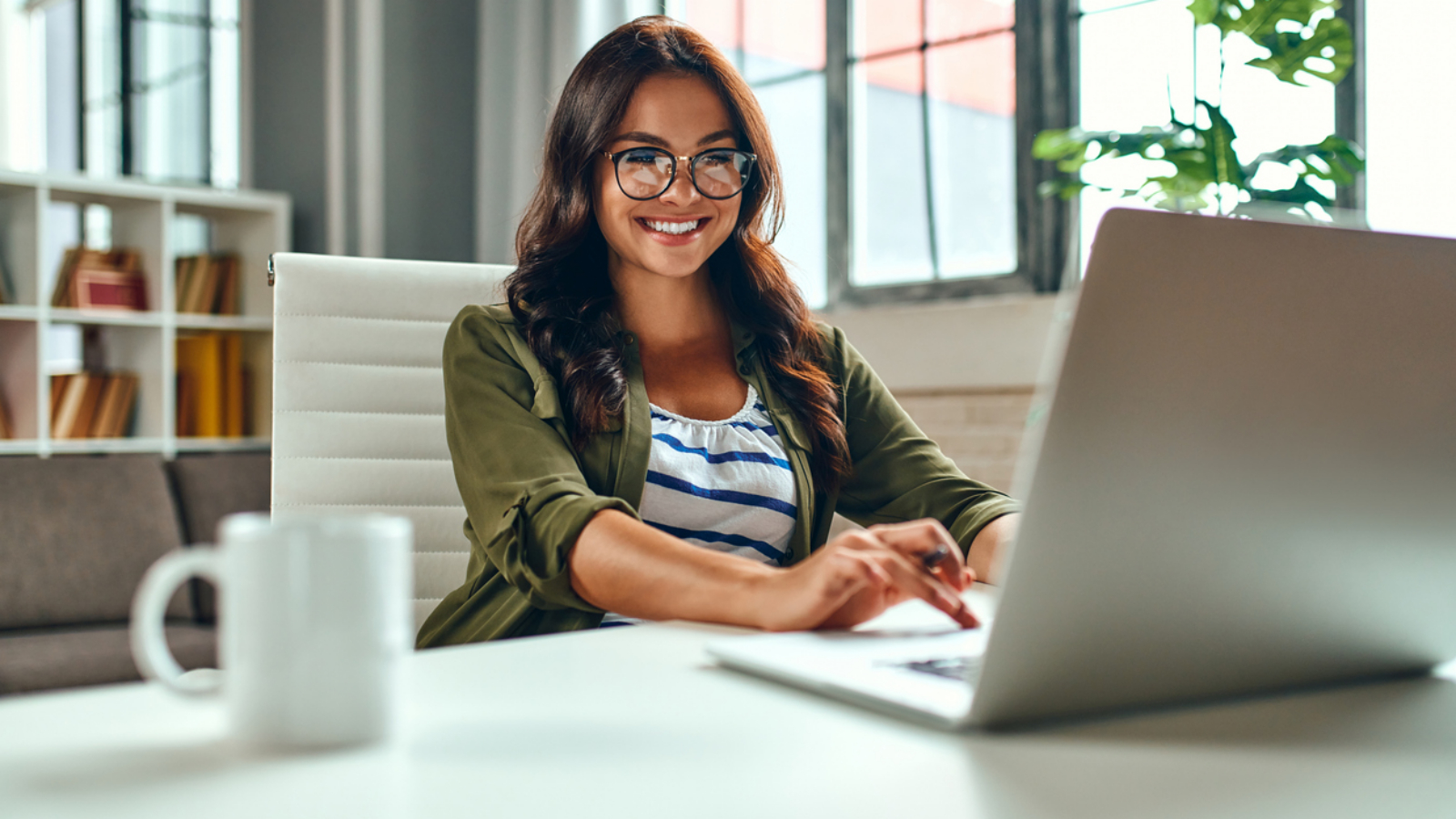Business woman working at the laptop while sitting at the table at home. Freelance, work from home.