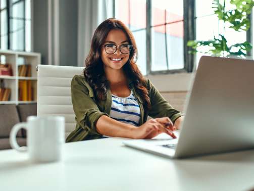 Business woman working at the laptop while sitting at the table at home. Freelance, work from home.