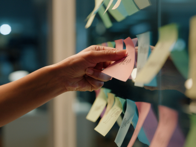 Hand, business and sticky note with planning, ideas and creativity for novel and schedule for writing.