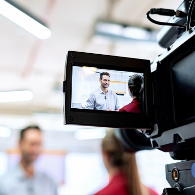 Video camera filming a man during inerview.