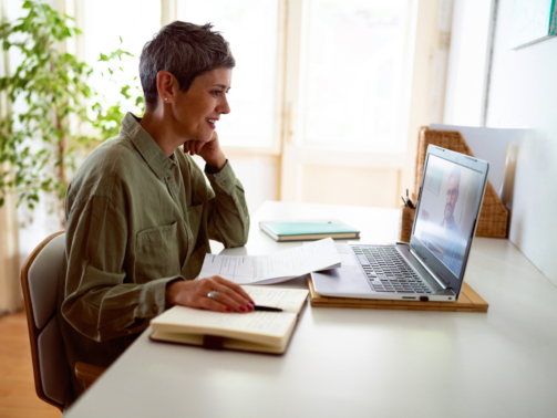 Woman following online courses on her laptop at home.
