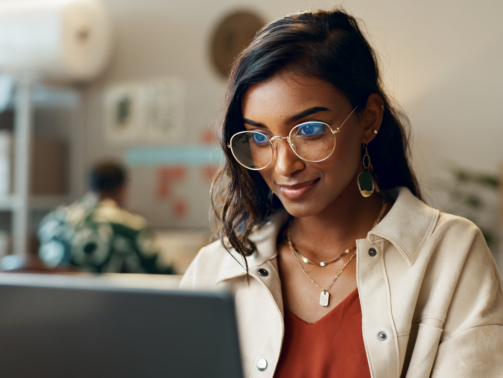 Woman, business and reading on laptop at work for research, feedback and supply chain for business. Indian, person and planning on pc for logistics, stock administration or package distribution data