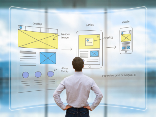Website development UI/UX front end designer reviewing sketched wireframe layout design mockup for responsive web content with AR screen