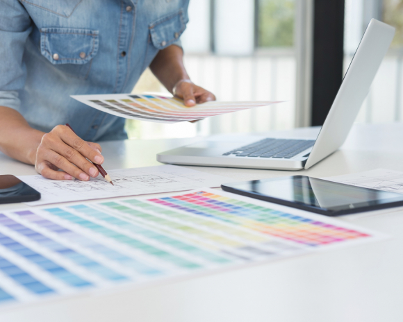 Color samples, colour chart, swatch sample, Graphic designer being selecting Color table and graphics tablet, pen at workplace with work example on wooden desk.