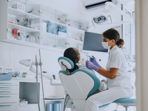 Dentist examining a patient in a modern dental clinic. Professional dental care and hygiene practice.