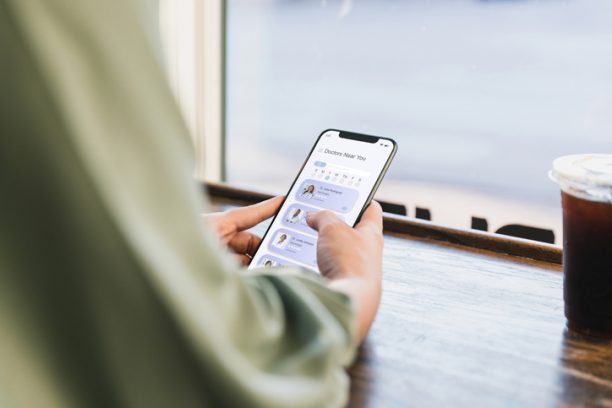 Sitting at a coffee shop, and unrecognizable young adult woman surfs the net for a new doctor.