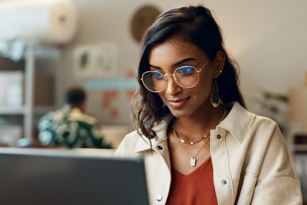 Woman, business and reading on laptop at work for research, feedback and supply chain for business. Indian, person and planning on pc for logistics, stock administration or package distribution data