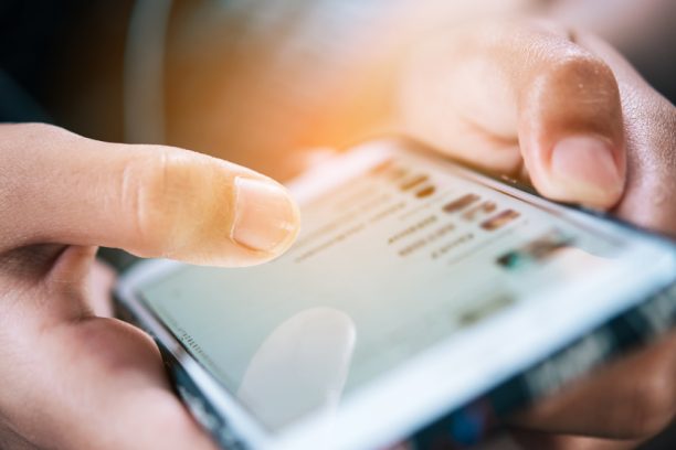 Midsection Of Person Using Mobile Phone