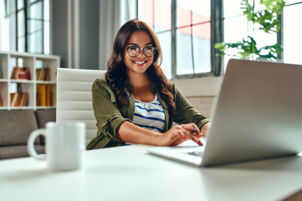 Business woman working at the laptop while sitting at the table at home. Freelance, work from home.